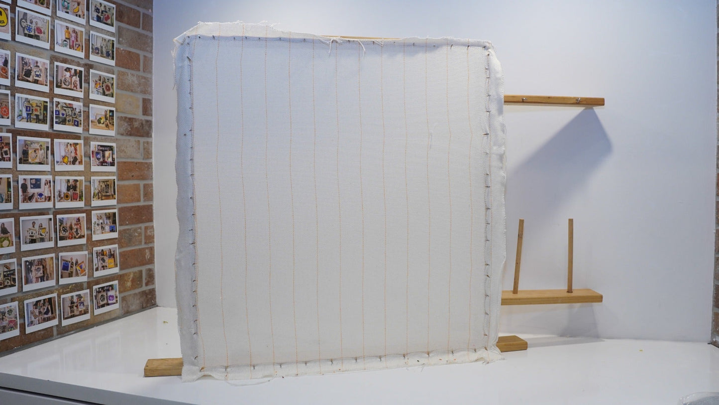 Primary tufting backing cloth stretched securely on a wooden frame