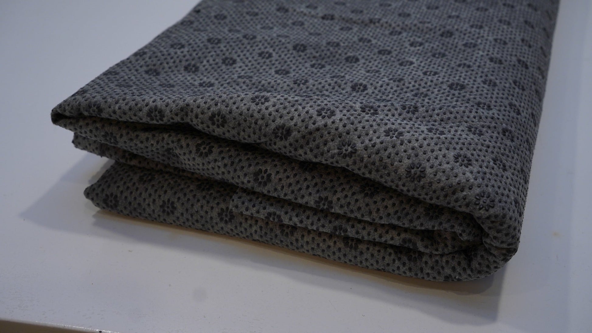 Black and grey non-slip rug backing cloth, folded product view