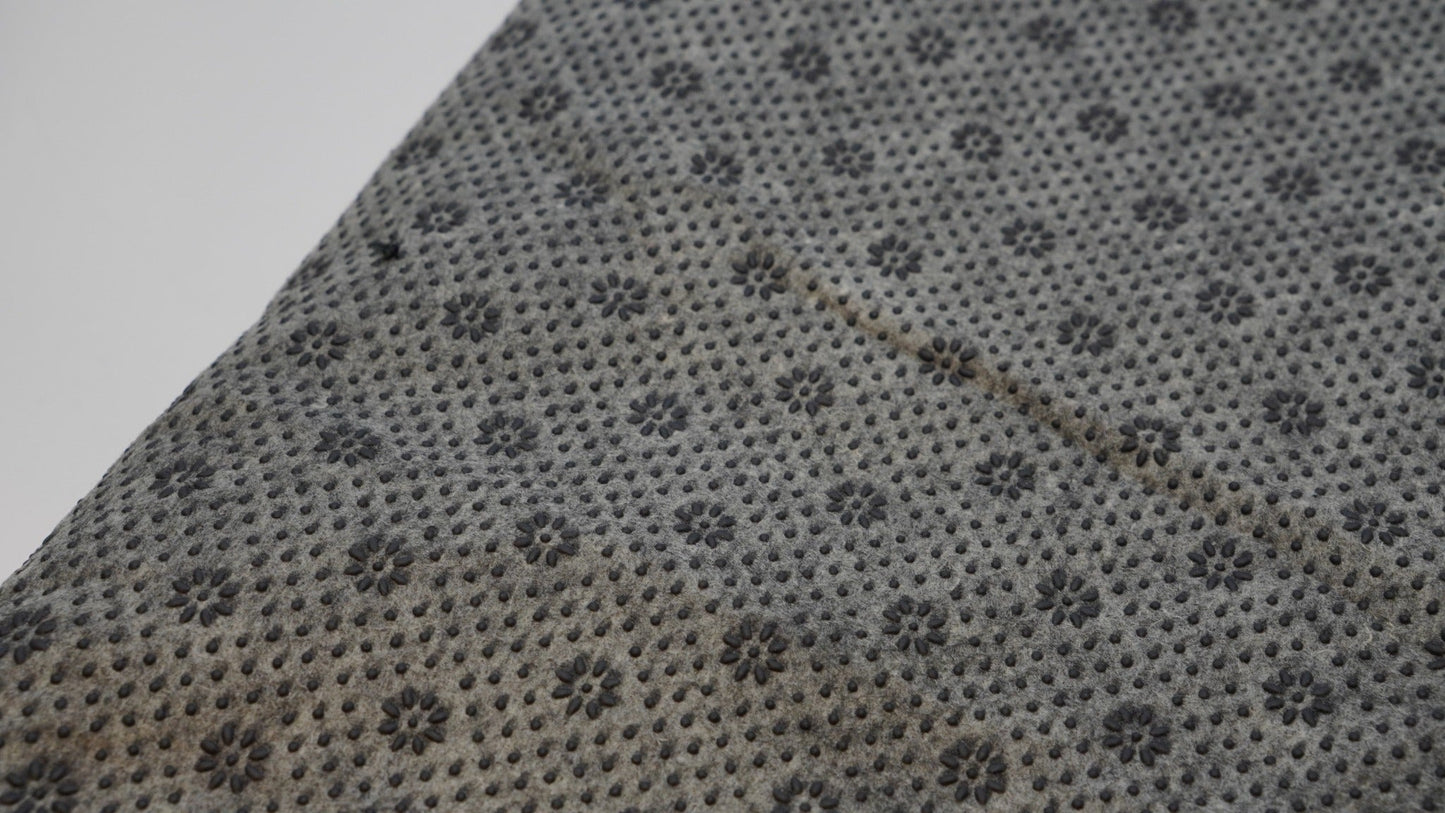 Grey non-slip backing cloth texture close-up