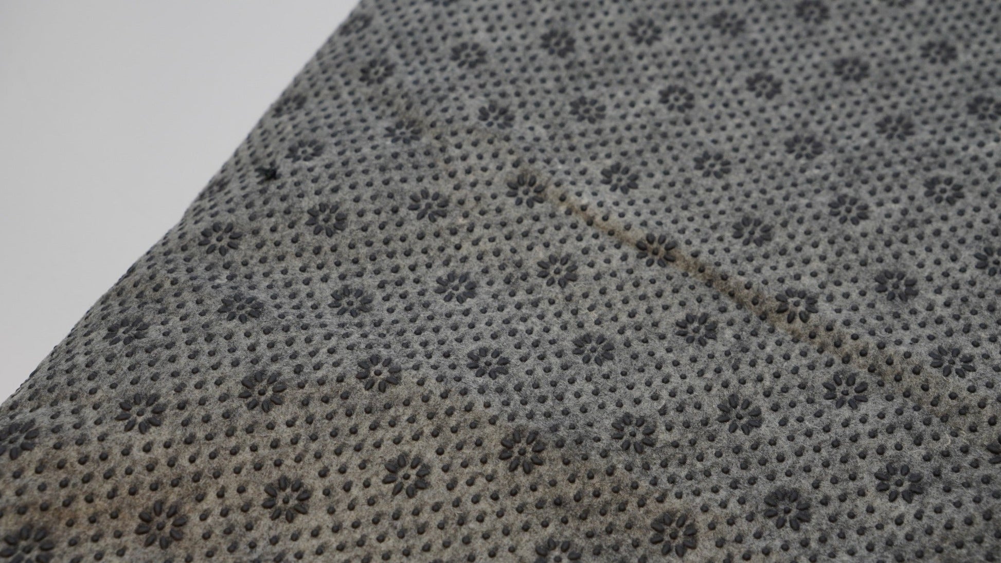 Grey non-slip backing cloth texture close-up