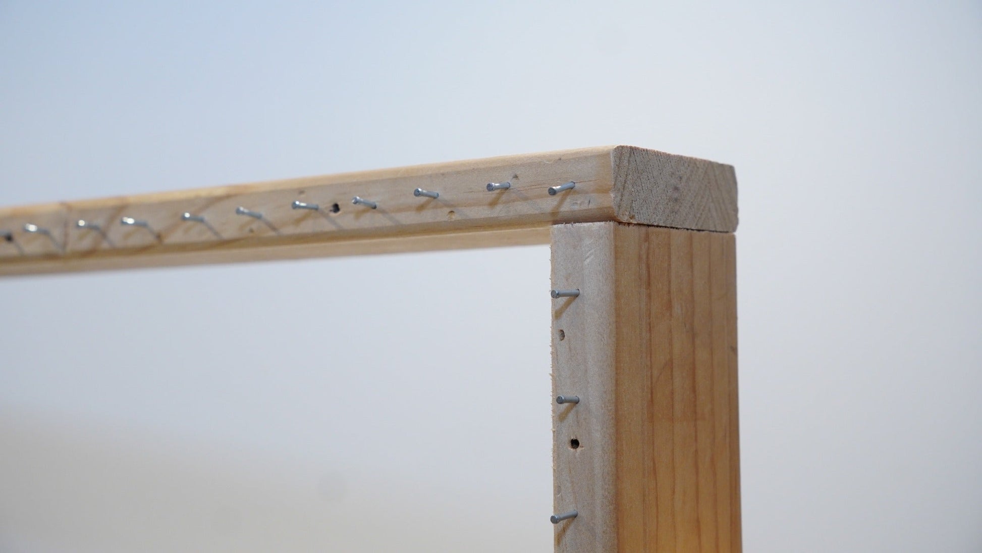 Close-up of gripper nails around the wooden tufting frame