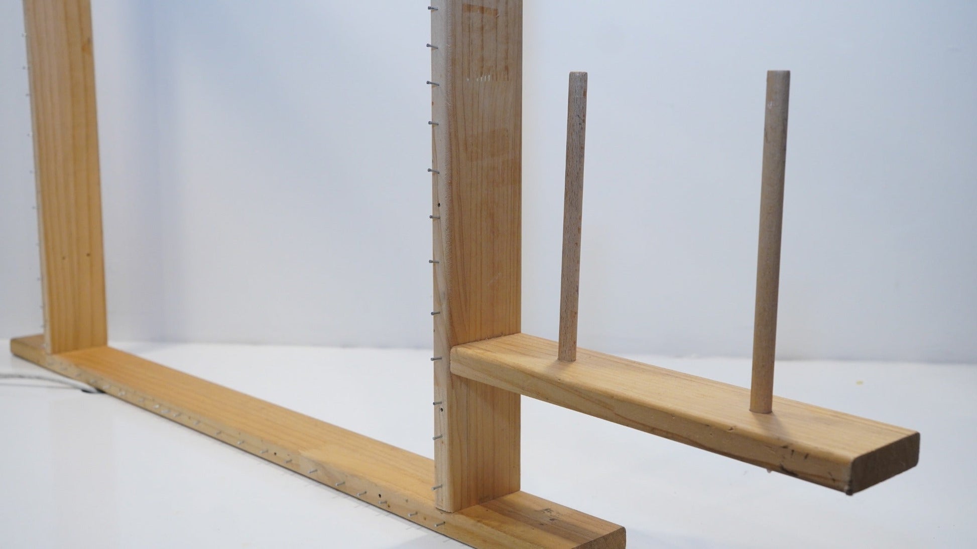 Integrated two-cone yarn holder on the adjustable wooden tufting frame
